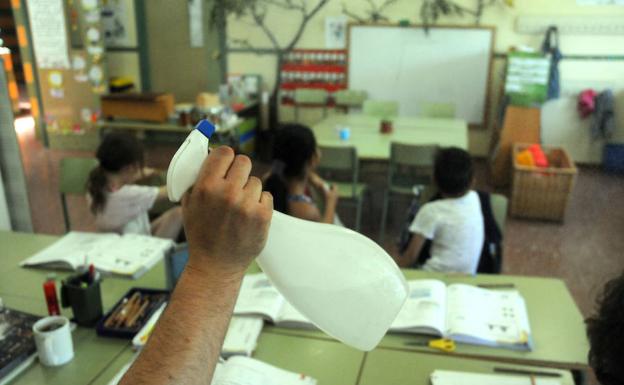 Un profesor del colegio José María Calatrava de Mérida refresca con un vaporizador a alumnos. :: / BRÍGIDO/