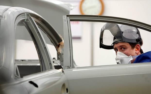 Un joven repara un automóvil.