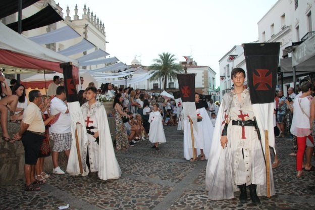 Vecinos y visitantes acompañan el pasacalles por el centro histórico de la villa.