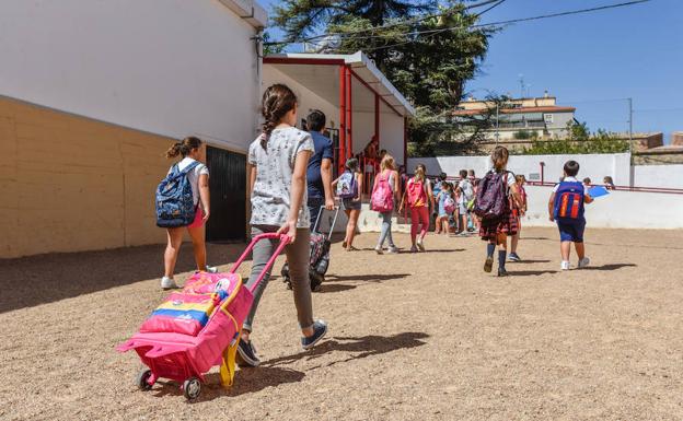 Alumnos del colegio Juventud este miércoles, atravesando el patio de tierra para llegar al comedor.