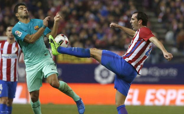 Luis Suárez y Godín disputan un balón. /Kiko Huesca (Efe)