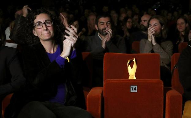 Marta Rovira coloca un lazo amarillo en protesta./Reuters