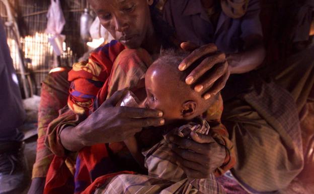 Un niño etíope bebe agua en brazos de su madre./Ap