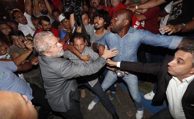 Lula da Silva (c) abandona la sede del Sindicato de los Metalúrgicos de Sao Bernardo do Campo (Brasil) en medio de un tumulto para entregarse a las autoridades. /Sebastião Moreira (Efe)