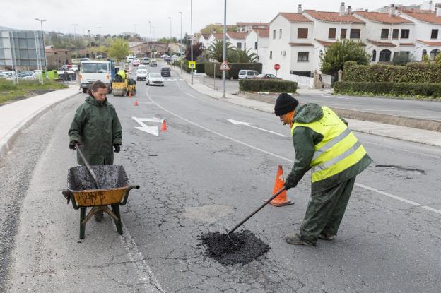Operarios reparan el asfalto en el Camino de las Huertas. :: a. solé/