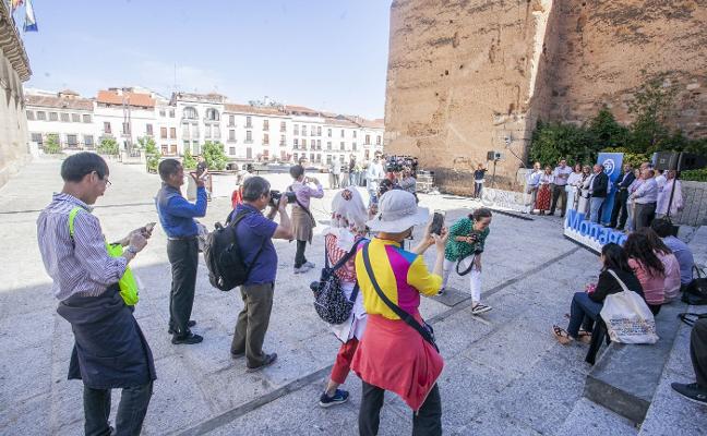Momento en el que los turistas orientales irrumpen como inesperado público del acto de Monago y lo fotografían con sus móviles. :: jorge rey/