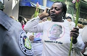Berta Soler, vestida con una camiseta con la imagen de su marido, habla por el móvil durante una marcha de las Damas de Blanco. ::
REUTERS/