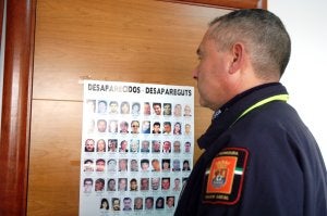 Pedro, el municipal que liberó a la chica, en la Policía Local, frente a un cartel con desaparecidos. :: BRIGI/