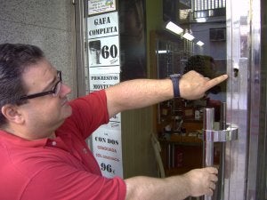 El comerciante muestra el bombín quitado de la cerradura. :: F. H./