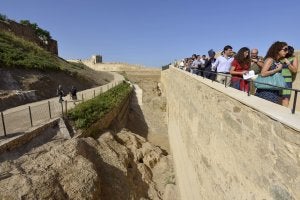 Visitantes andan por la muralla rehabilitada de la Alcazaba, un monumento que entra en el estudio. :: HOY/