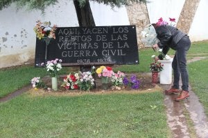 Una mujer coloca flores en la zona del cementerio donde se rinde homenaje a las víctimas. :: HOY/