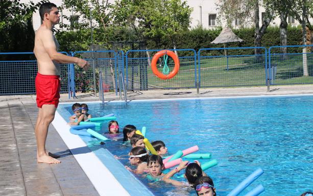 Uno de los monitores enseña a los niños a nadar en la piscina municipal. 