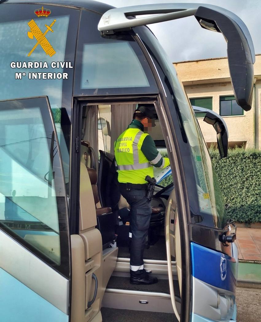 Un agente de la Guardia Civil de Tráfico realiza una inspección en un autobús de transporte escolar. 
