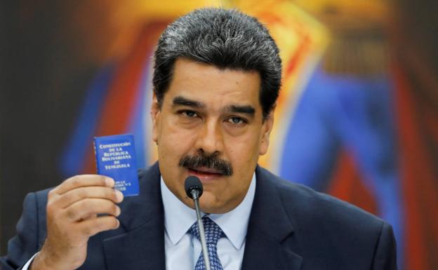 Nicolás Maduro sujeta un pequeño ejemplar de la Constitución venezolana en su último mensaje al país./Reuters