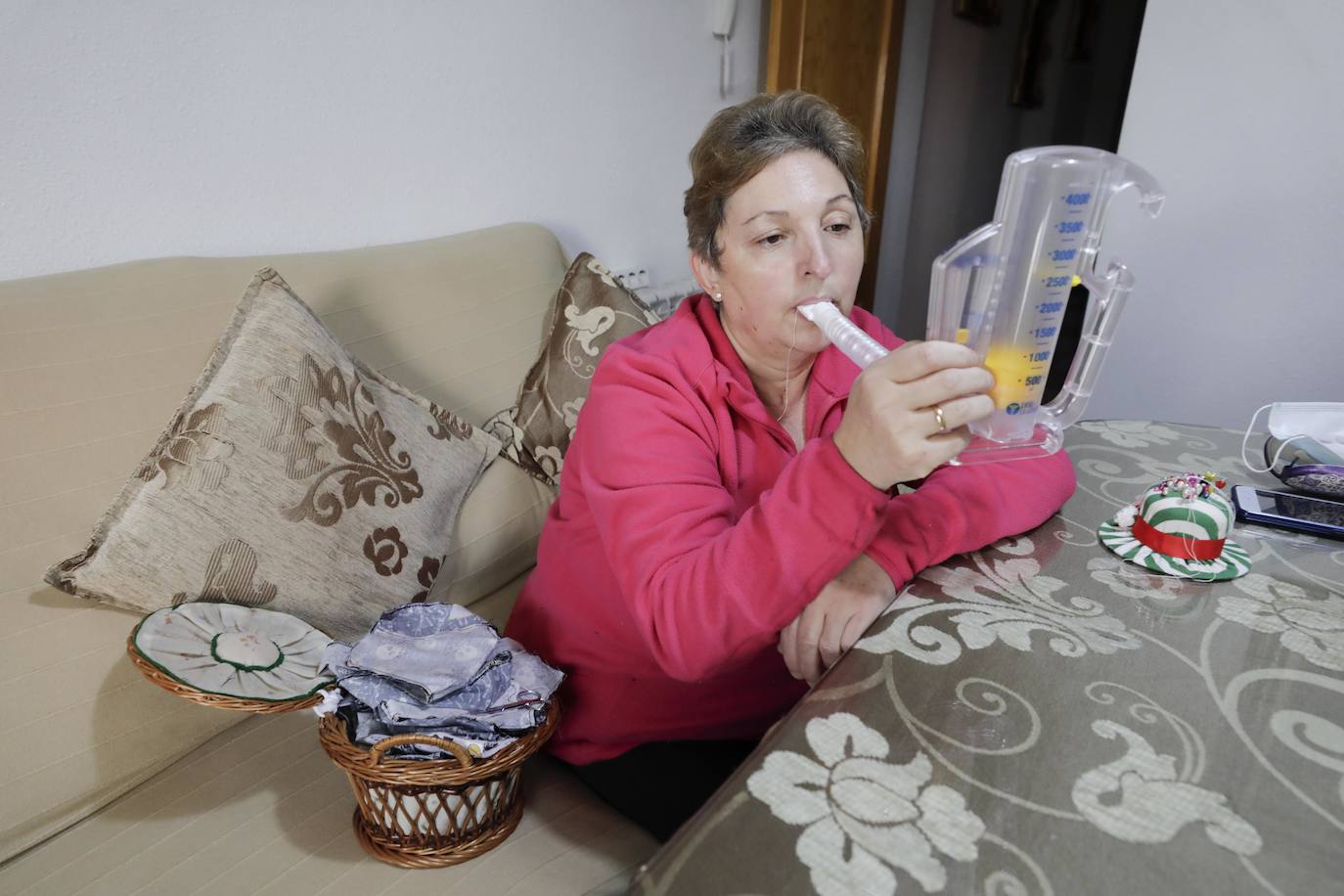 Mª Paz Maya, que ha necesitado andador, usando su ejercitador respiratorio.