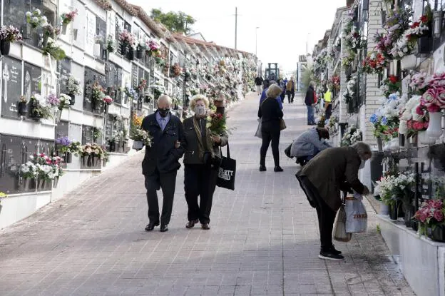 Varios cacereños adecentan los nichos de sus seres queridos. / LORENZO CORDERO