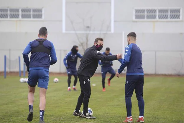 Manuel saluda a un futbolista azulgrana en el entrenamiento. / J. M. ROMERO