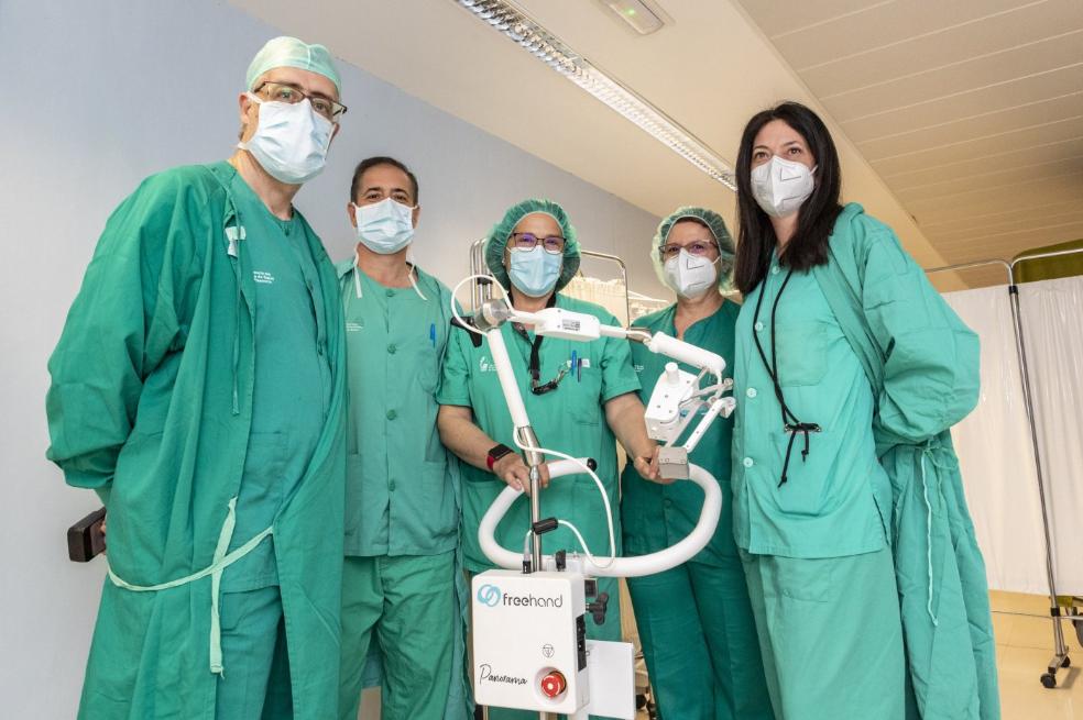 Parte del equipo de Cirugía del hospital Virgen del Puerto, con el asistente 'Freenhand'. De izquierda a derecha, los doctores Benito, Costa, Alarcón y Méndez, y la enfermera Pintiado. / ANDY SOLÉ