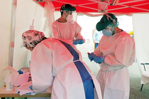 Sanitarios realizando pruebas PCR en un punto de cribado en Don  Benito. / E. DOMEQUE