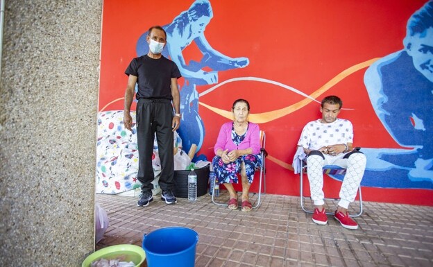 Joaquín Suárez (izqda.), con su madre y su hermano en los soportales de un bloque de Nuevo Cáceres. /JORGE REY