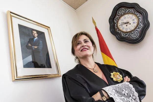 Elena Sánchez, en su despacho, junto a la foto del Rey, la bandera de España y el reloj de los juzgados placentinos. / ANDY SOLÉ