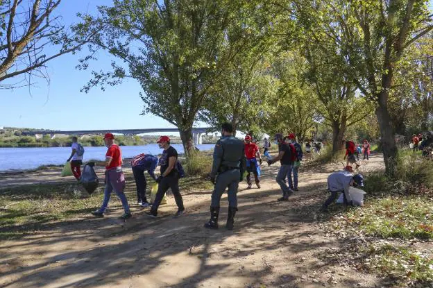 Un grupo de voluntarios limpiando ayer el Guadiana. / J. M. ROMERO