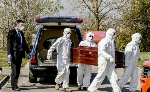 Trabajadores de una funeraria trasladan un féretro. /Efe