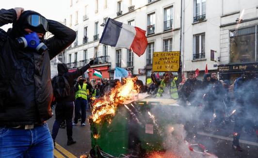 Contenedores de basura en llamas durante una protesta convocada este sábado por organizaciones juveniles en París. /Reuters